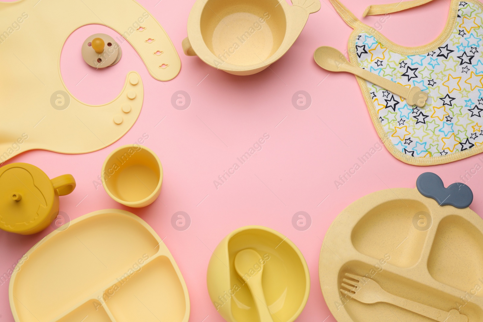 Photo of Baby feeding accessories and bib on pink background, flat lay. Space for text