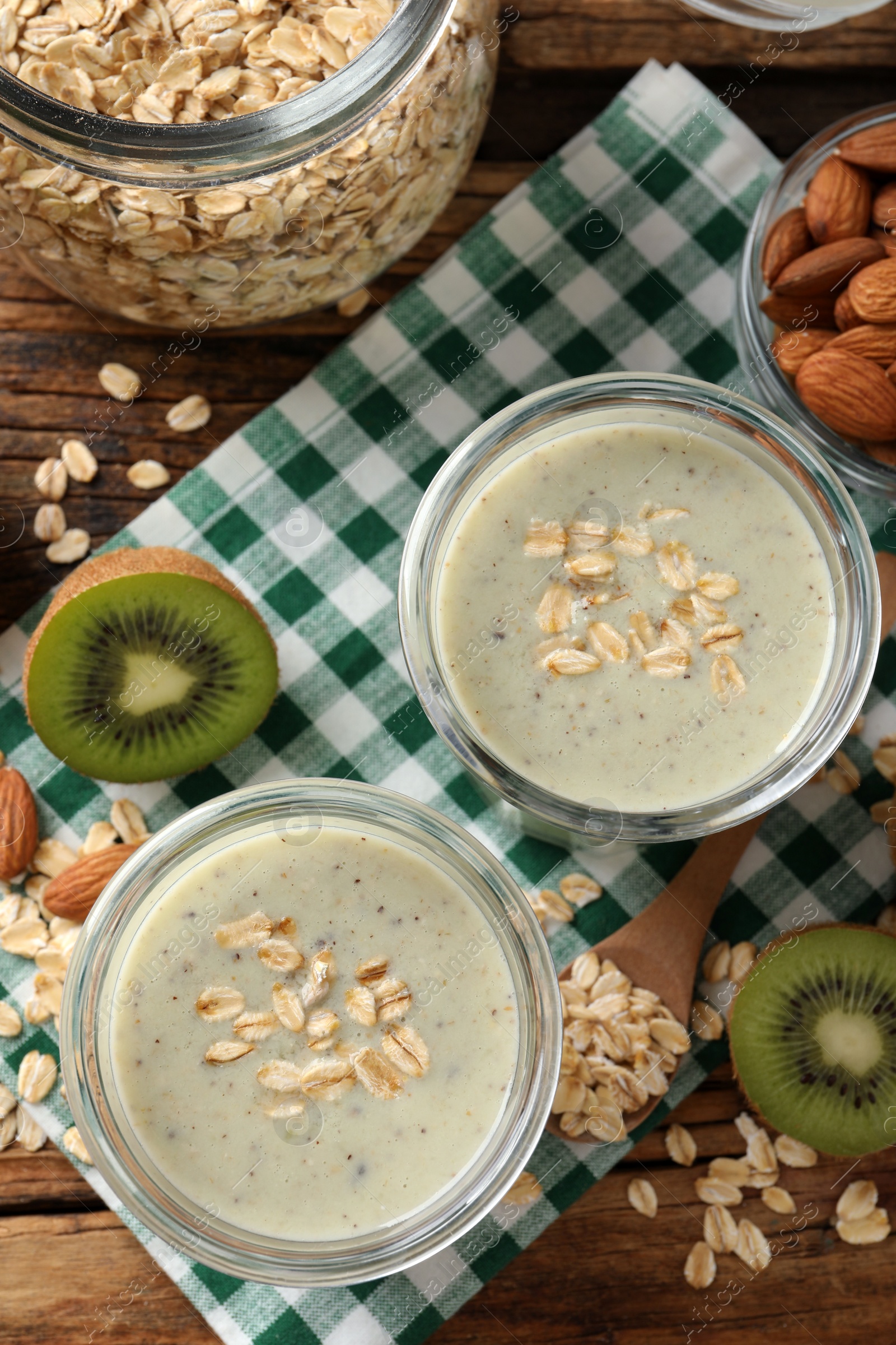 Photo of Flat lay composition with tasty kiwi oatmeal smoothie on wooden table