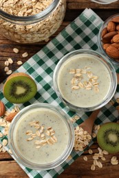 Flat lay composition with tasty kiwi oatmeal smoothie on wooden table