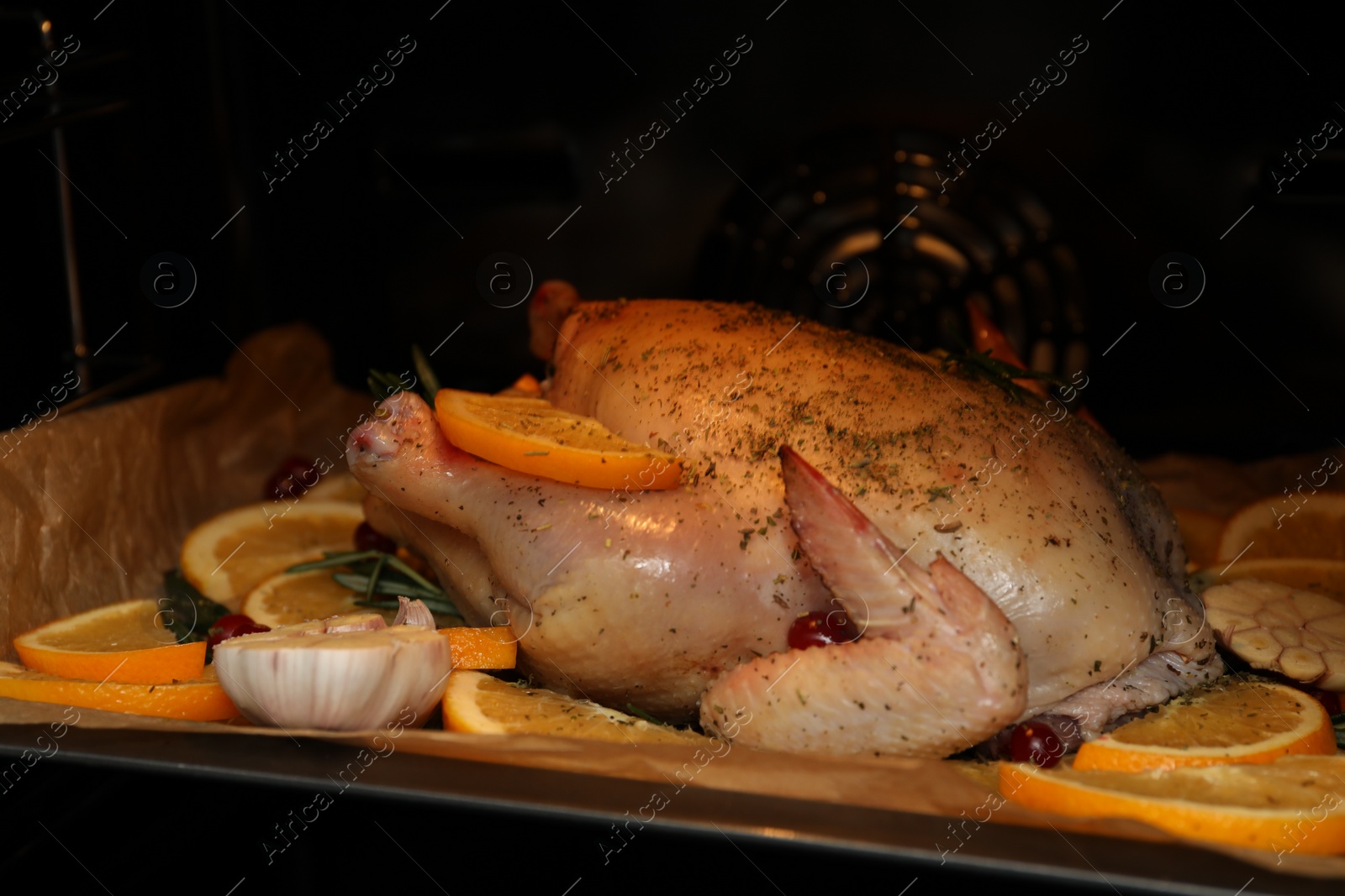 Photo of Chicken with orange slices baking in oven