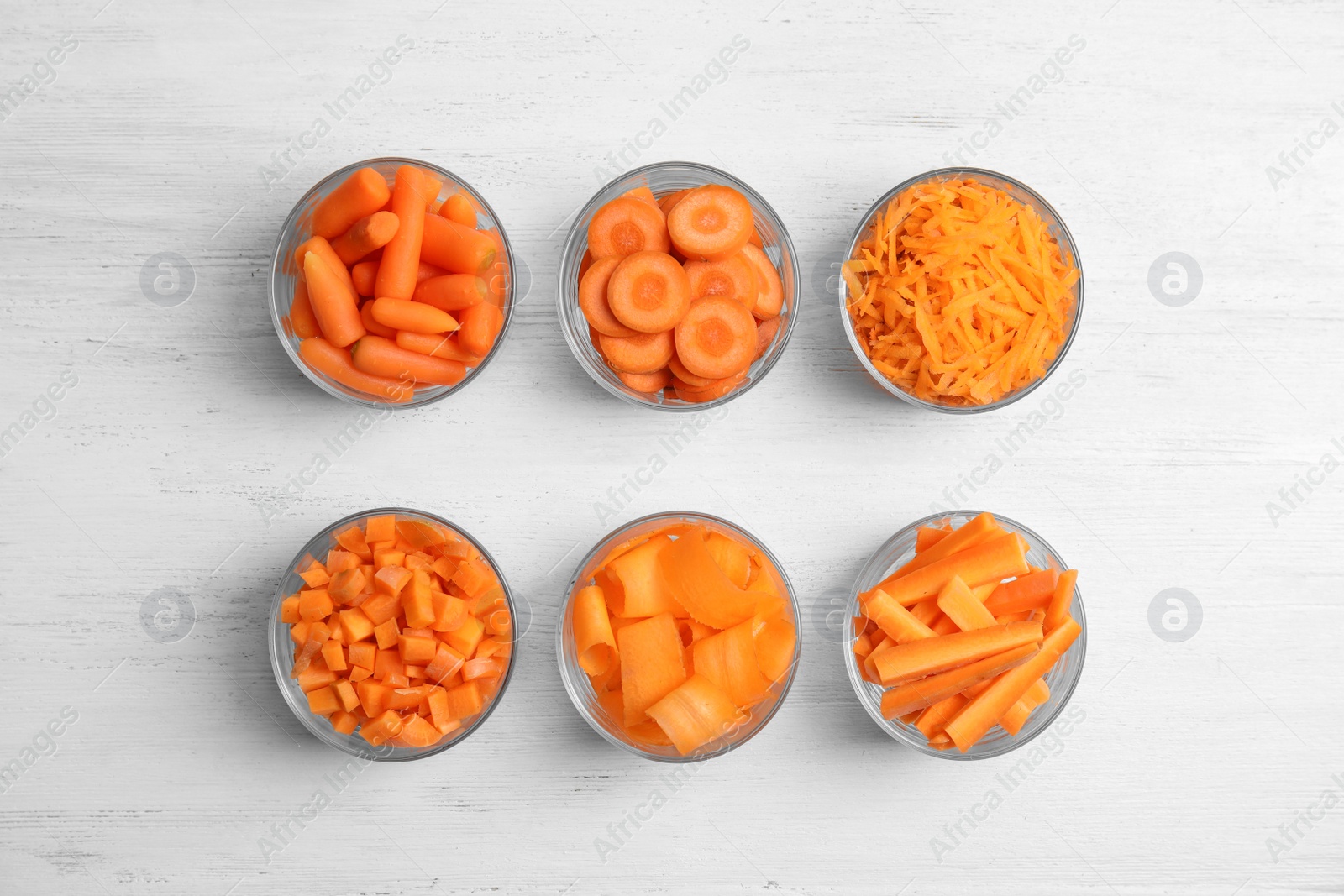 Photo of Flat lay composition with cut carrots on wooden background