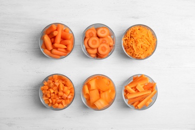 Photo of Flat lay composition with cut carrots on wooden background