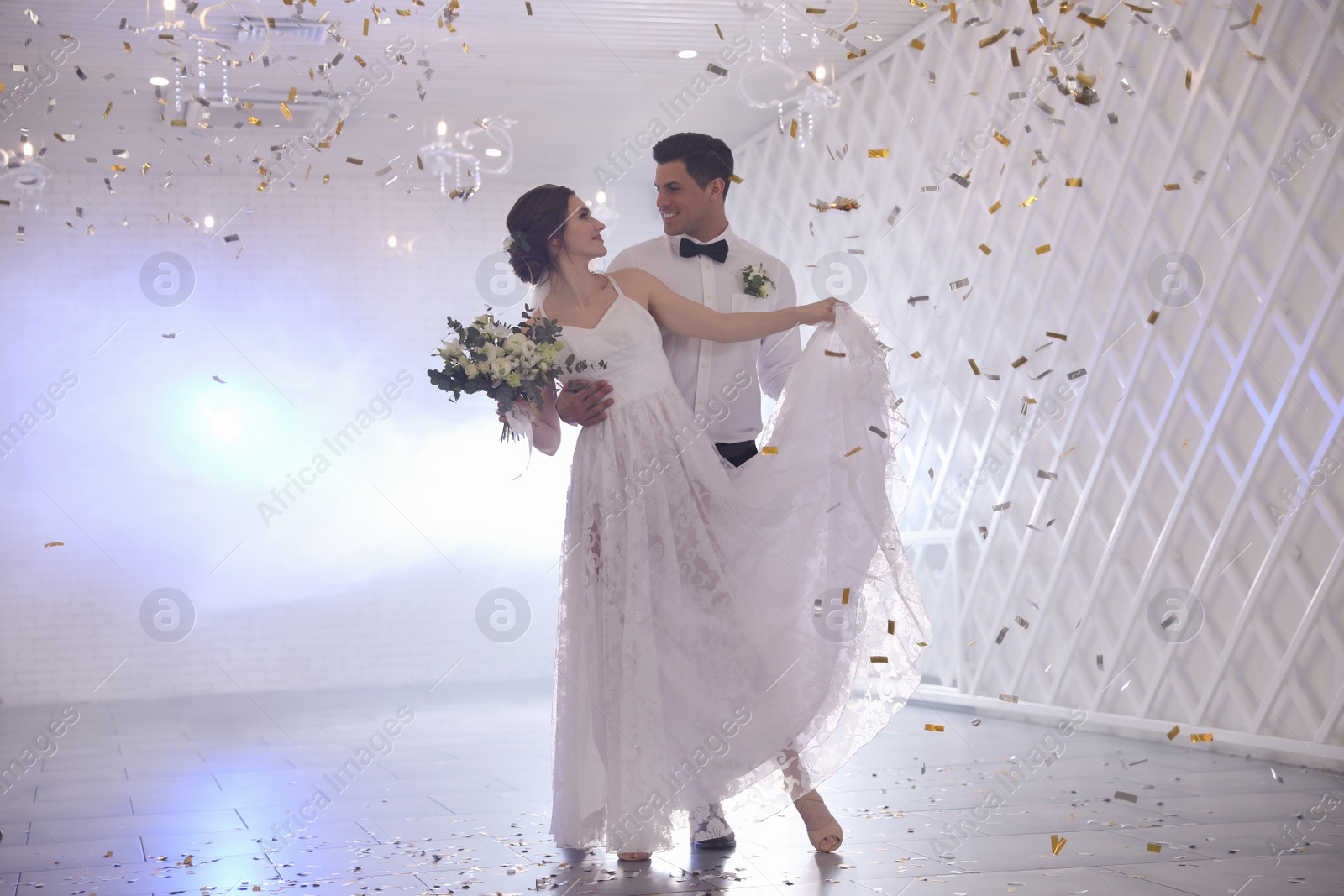 Photo of Happy newlywed couple dancing together in festive hall