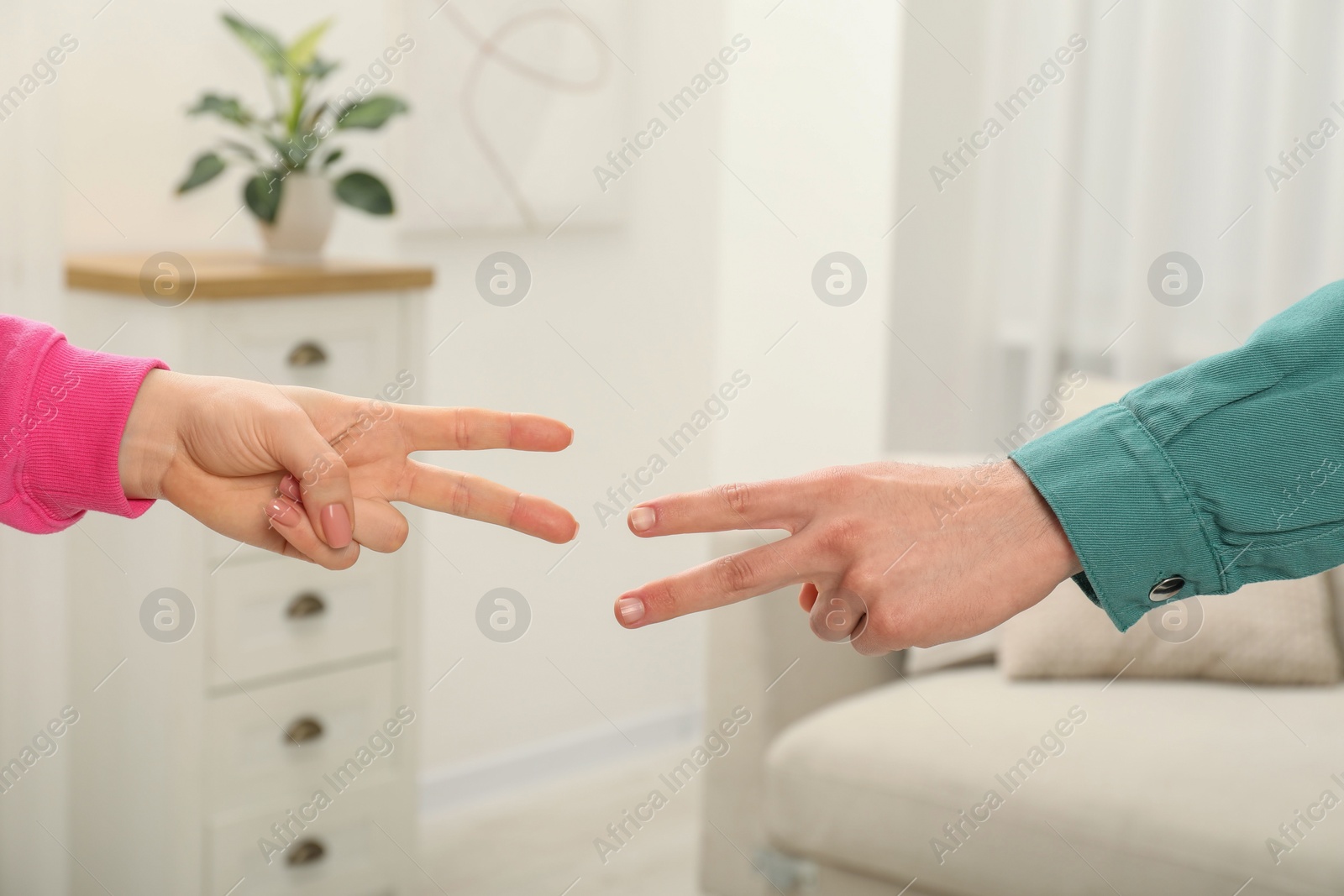 Photo of People playing rock, paper and scissors indoors, closeup