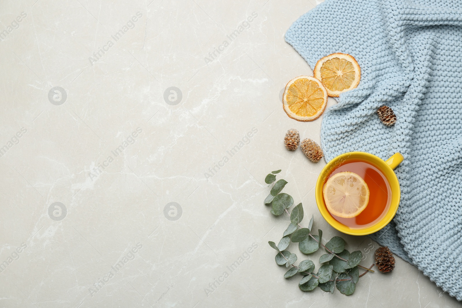 Photo of Flat lay composition with tea and warm plaid on light marble table, space for text