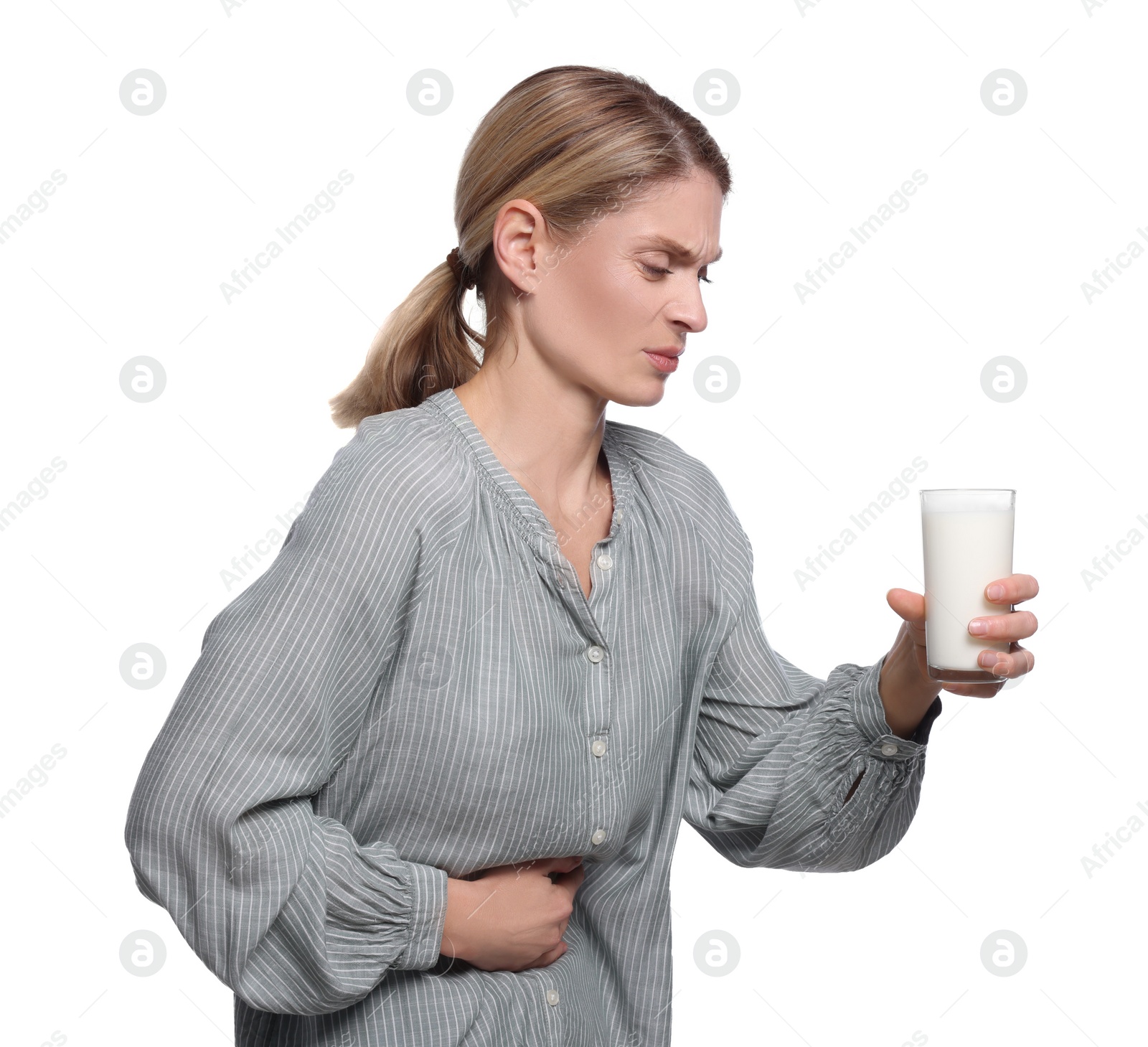 Photo of Woman with glass of milk suffering from lactose intolerance on white background