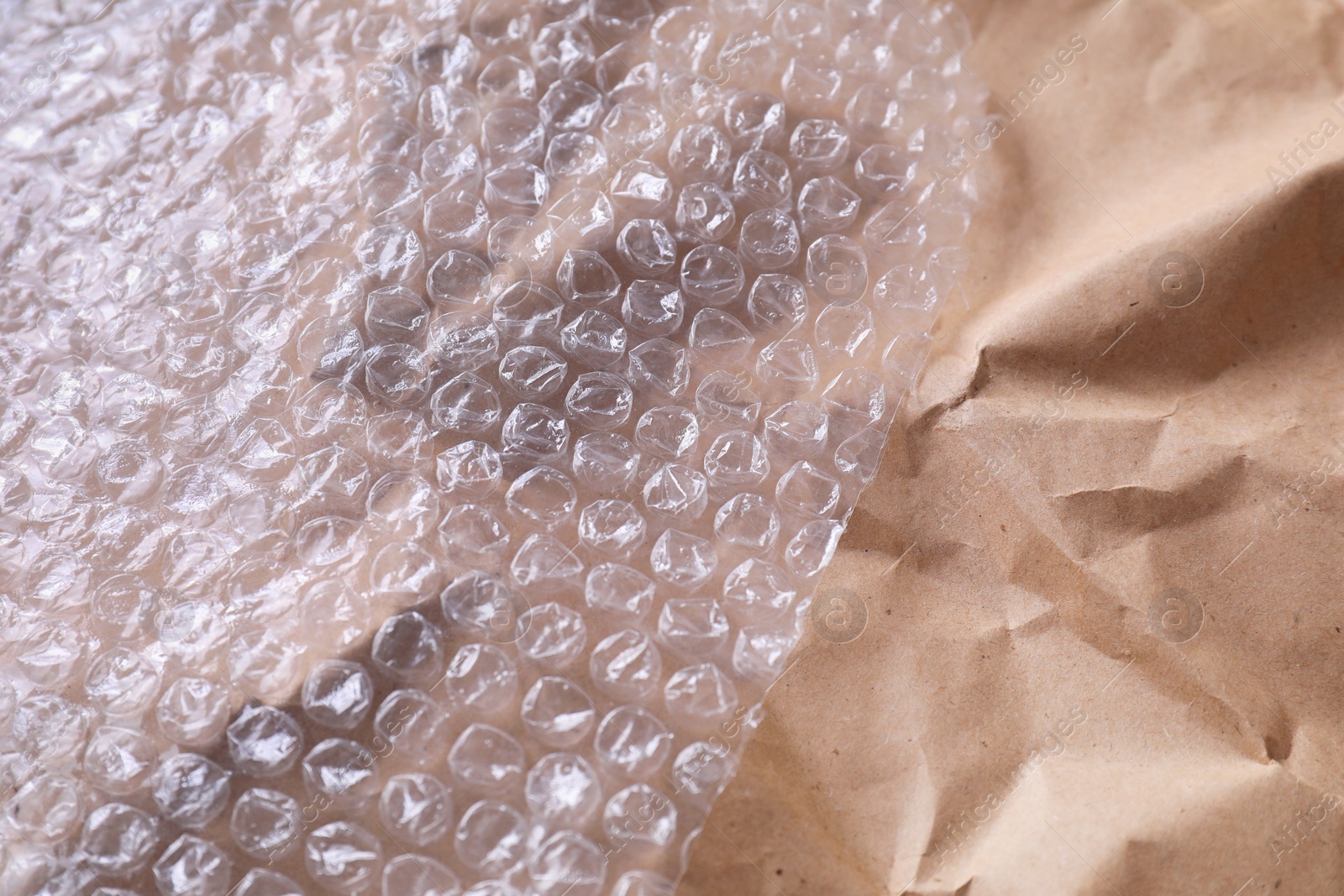 Photo of Transparent bubble wrap on kraft paper, closeup