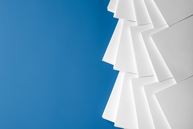 Photo of Many stacks of paper sheets on blue background, flat lay. Space for text