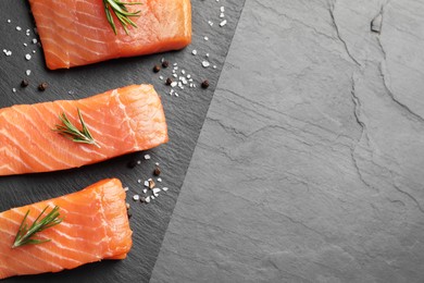 Photo of Fresh raw salmon and spices on black table, flat lay. Space for text