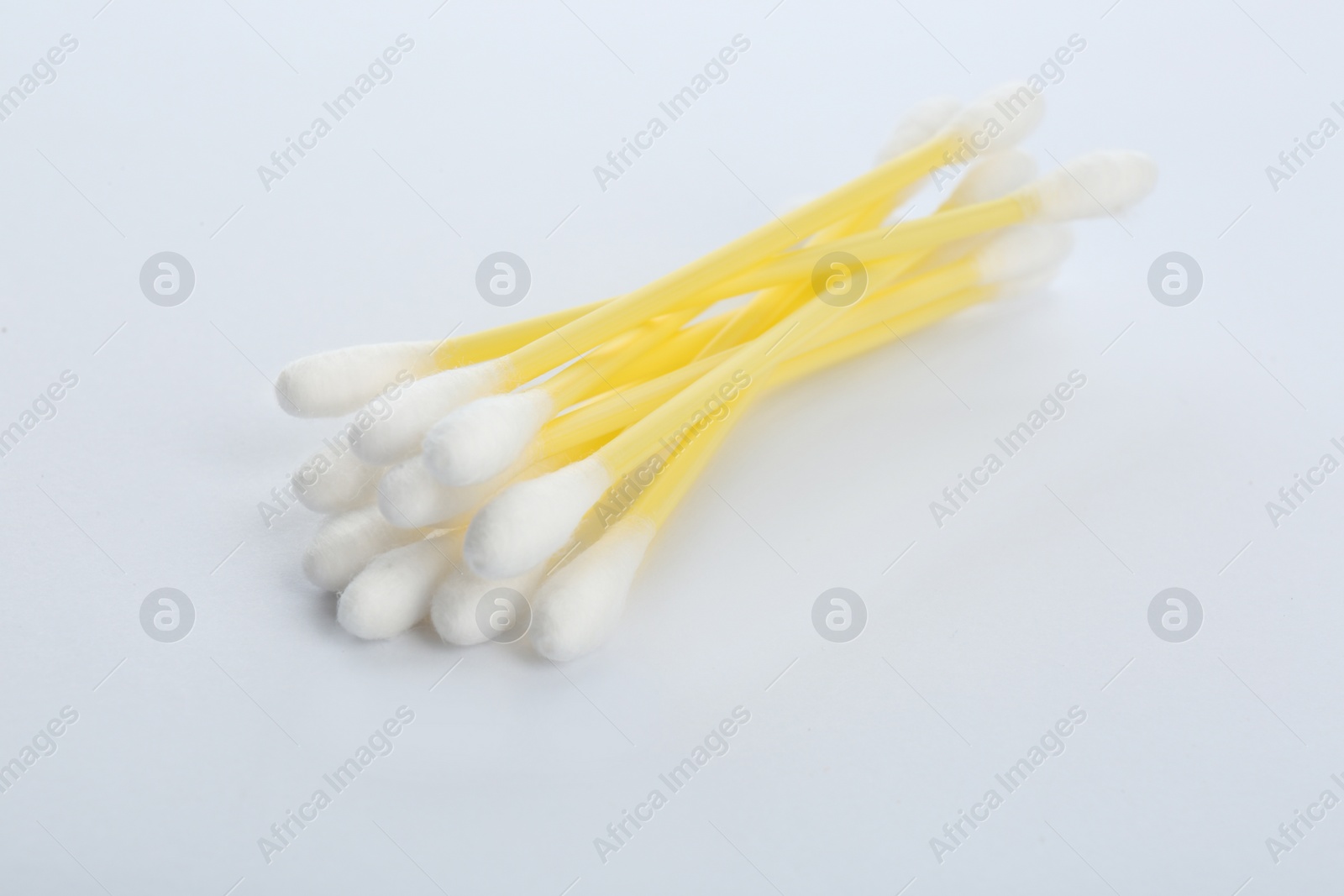 Photo of Yellow plastic cotton swabs on white background