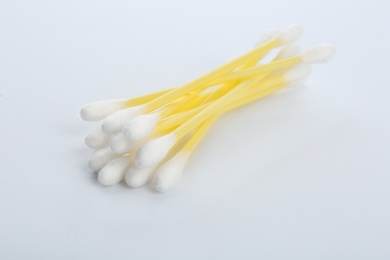 Photo of Yellow plastic cotton swabs on white background