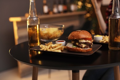 Photo of Tasty burger and french fries served on table in cafe