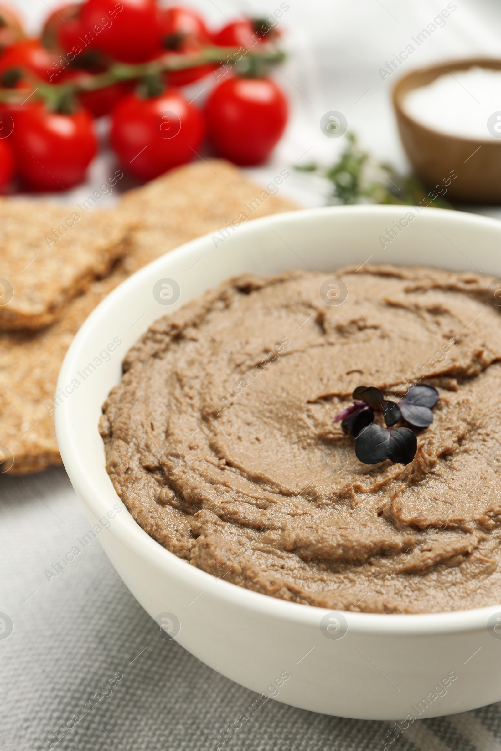 Photo of Tasty liver pate with herb in bowl on table, closeup