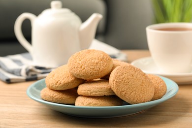 Photo of Delicious sugar cookies and tea on wooden table