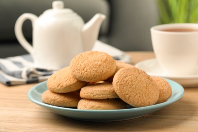 Delicious sugar cookies and tea on wooden table