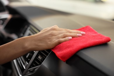 Photo of Woman cleaning car interior with rag, closeup