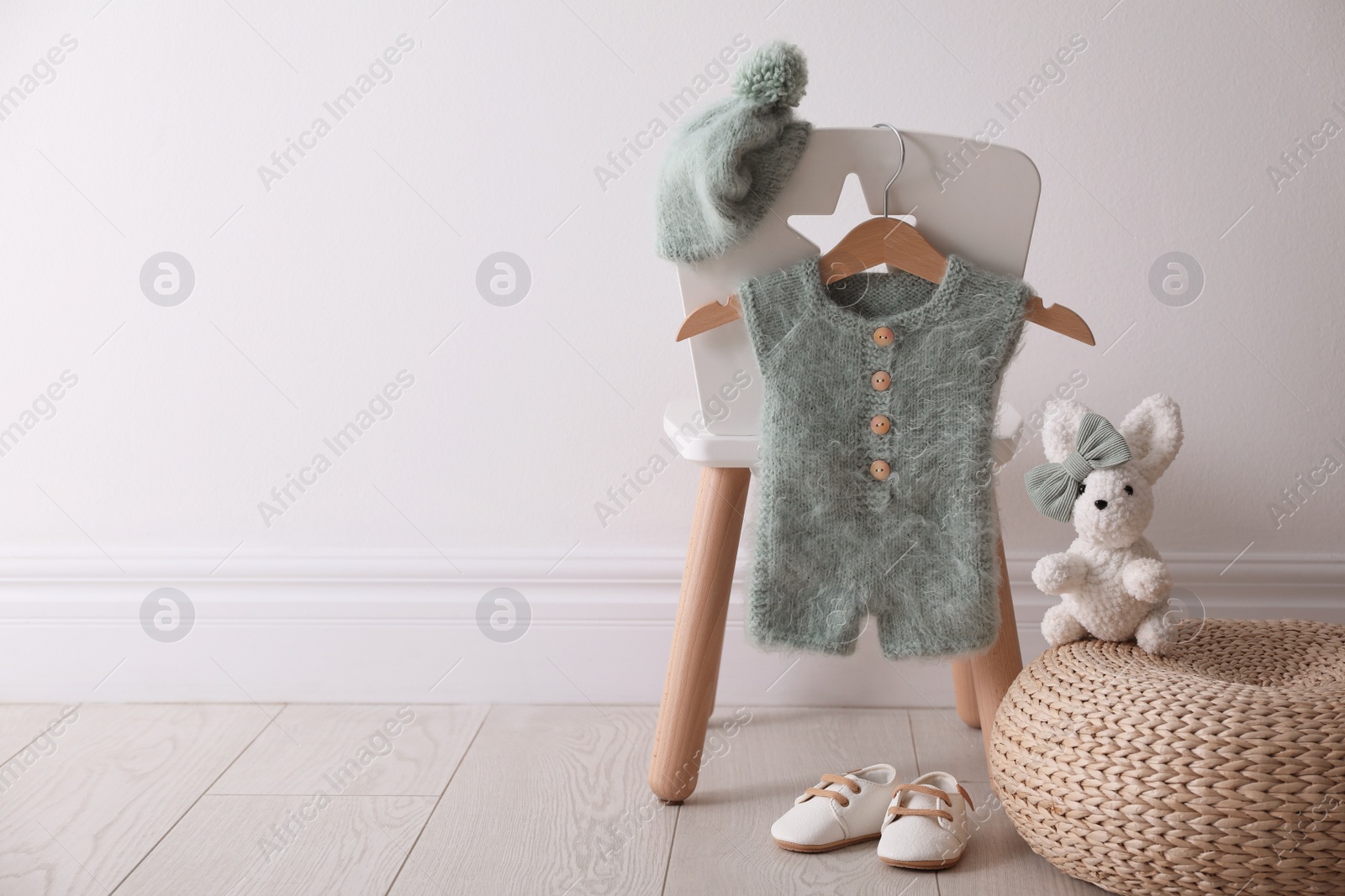 Photo of Set of children's clothes and shoes in room. Space for text