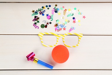 Flat lay composition with clown's items on white wooden table