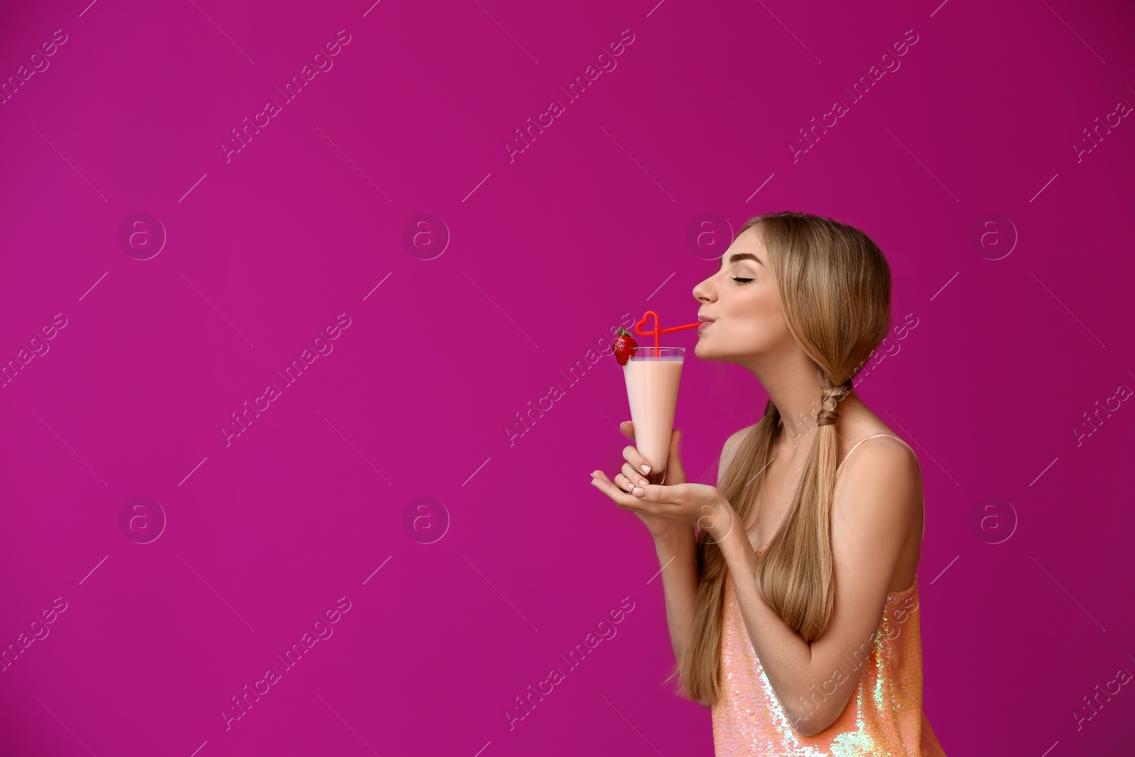 Photo of Young woman with glass of delicious milk shake on color background