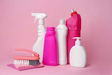 Cleaning supplies and tools on pink background