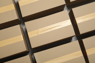 Photo of Many closed cardboard boxes with tape on light grey background, flat lay