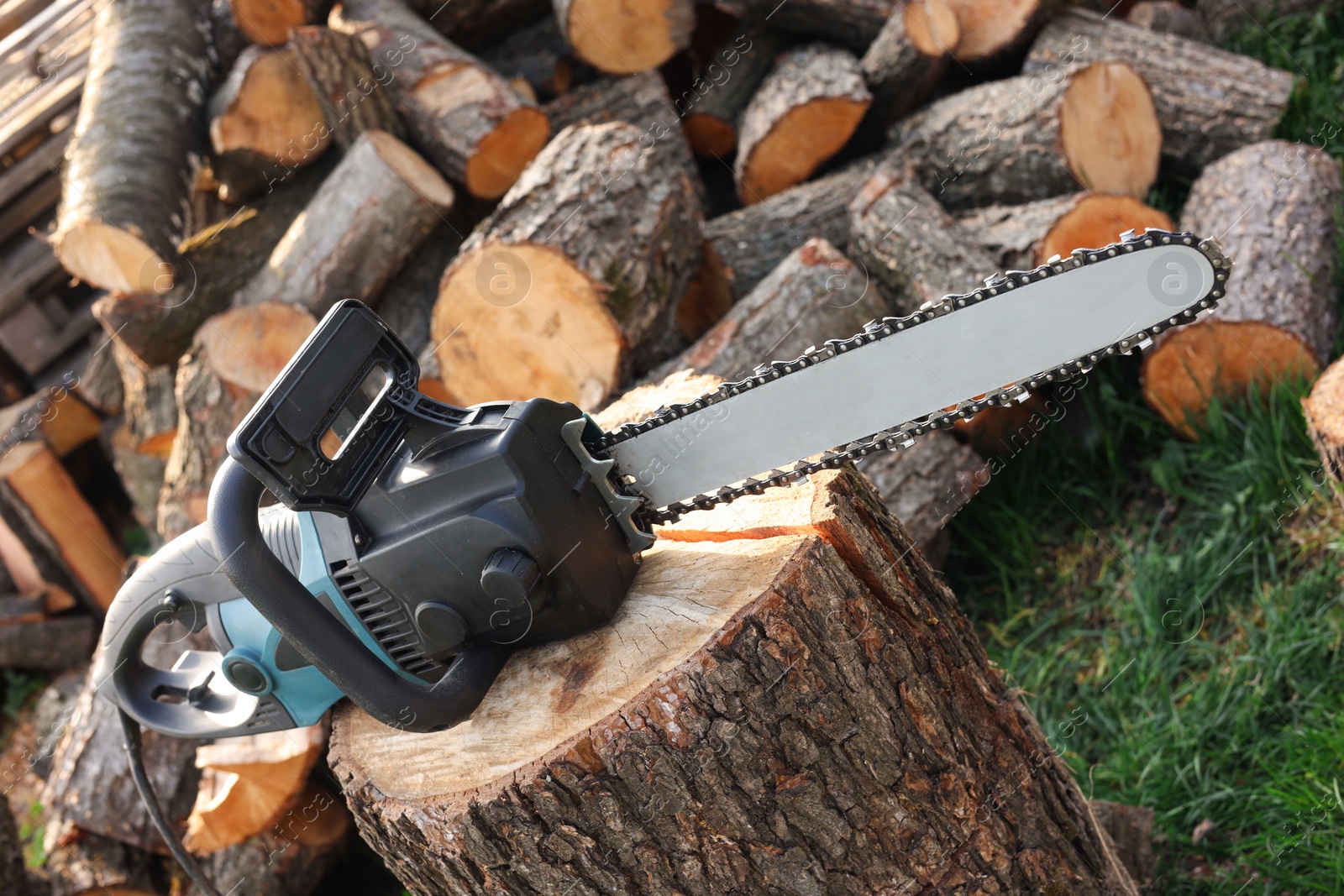 Photo of One modern saw on wooden log outdoors