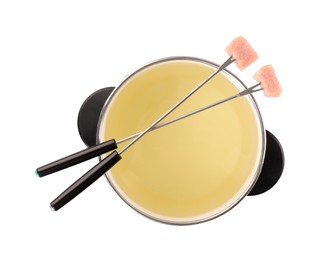 Photo of Oil in fondue pot and forks with pieces of raw meat isolated on white, top view