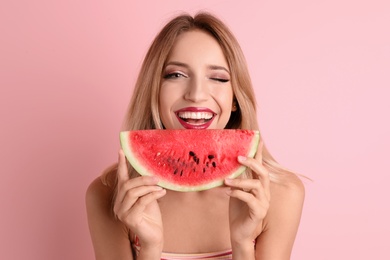 Pretty young woman with juicy watermelon on color background