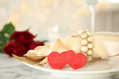 Photo of Elegant table setting for romantic dinner against blurred festive lights. Valentine's day celebration