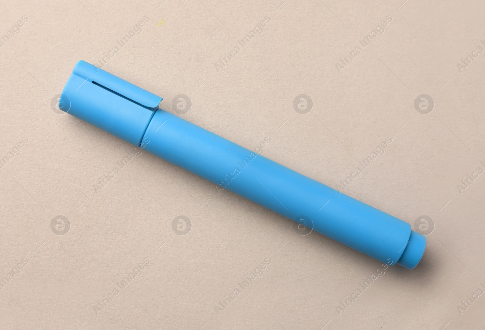 Photo of Bright light blue marker on beige background, top view
