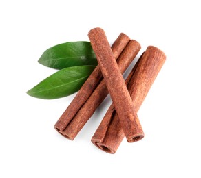 Cinnamon sticks and green leaves isolated on white, top view