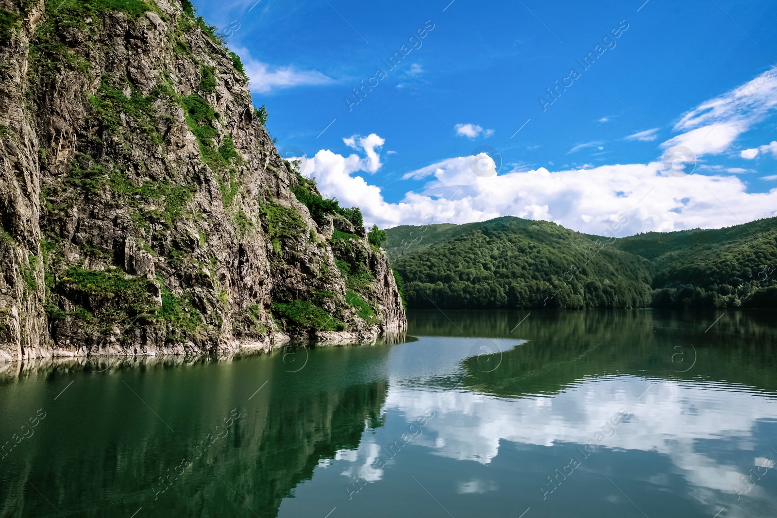 Photo of Picturesque view of beautiful lake surrounded by mountains on sunny day