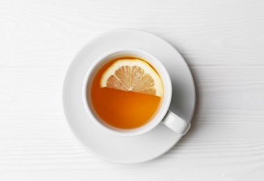 Cup with delicious immunity boosting tea and lemon on white wooden table, top view