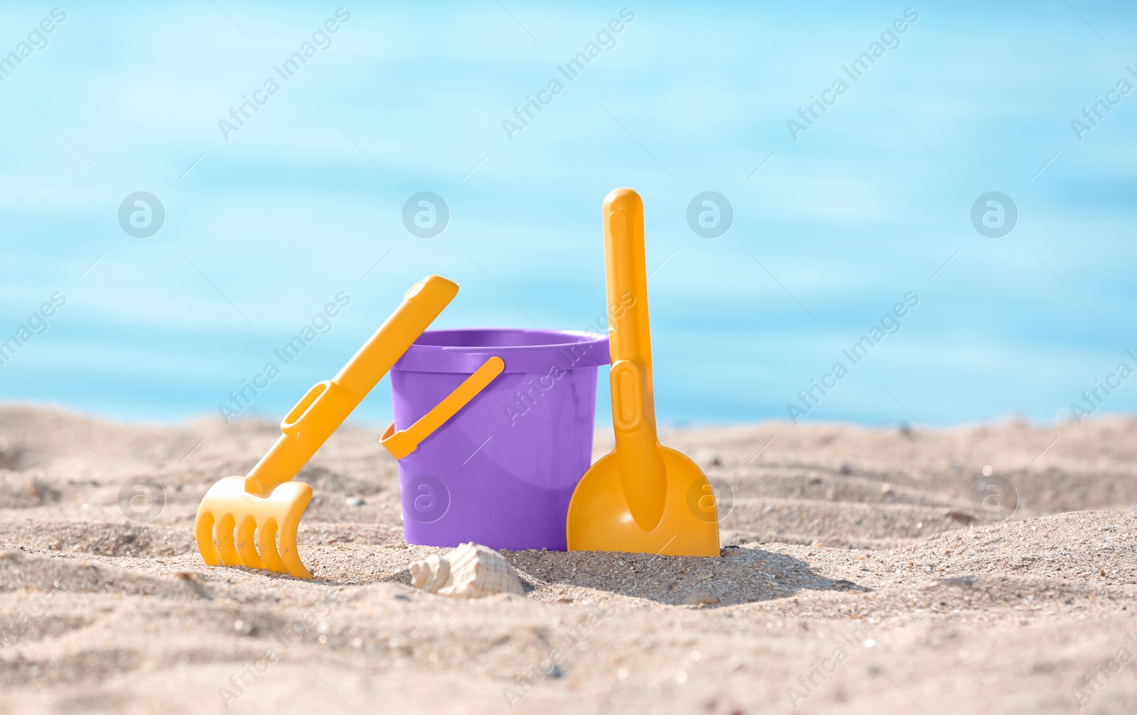 Photo of Children toys on sand near sea. Beach object