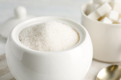 Photo of Ceramic bowl with white sugar, closeup view