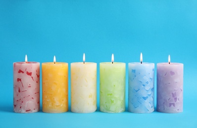 Photo of Alight scented wax candles on color background