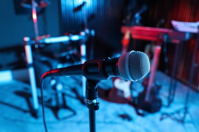 Photo of Modern microphone at recording studio, color toned. Music band practice