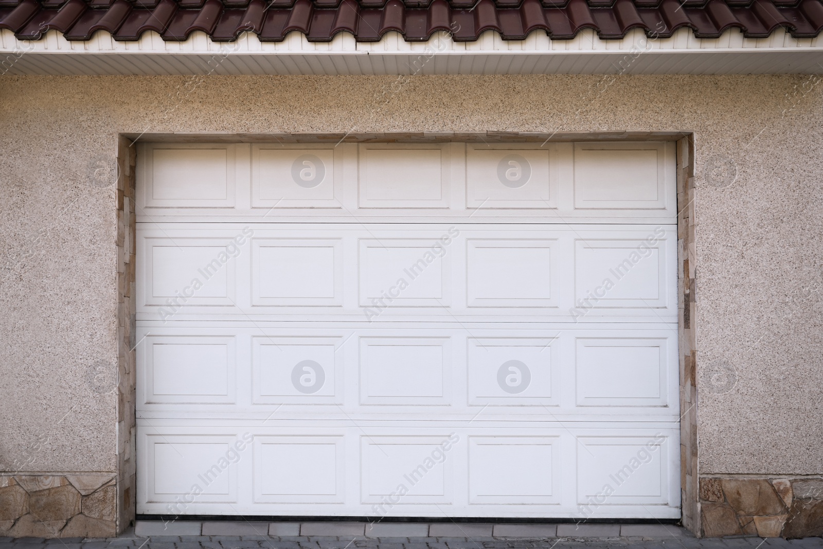 Photo of White modern sectional garage doors on building