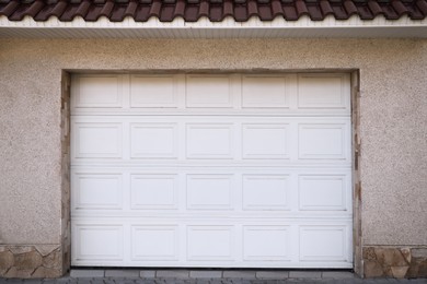 Photo of White modern sectional garage doors on building
