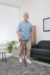 Senior man with walking cane at home