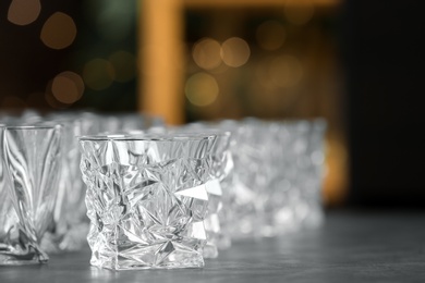 Photo of Empty glasses on table against blurred background. Space for text