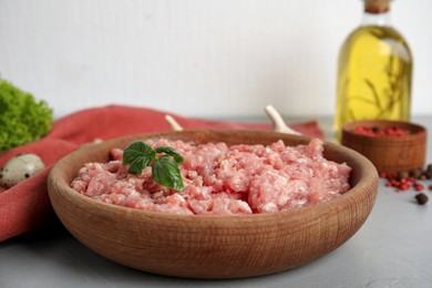 Photo of Raw chicken minced meat with basil on grey table