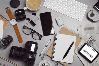 Photo of Flat lay composition with equipment for journalist on grey stone table