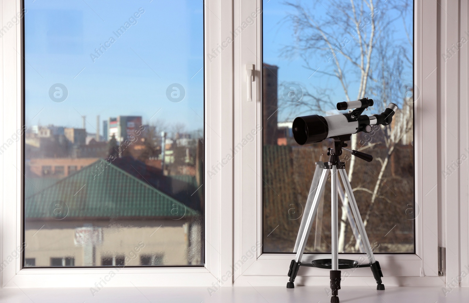 Photo of Tripod with modern telescope on windowsill indoors. Space for text