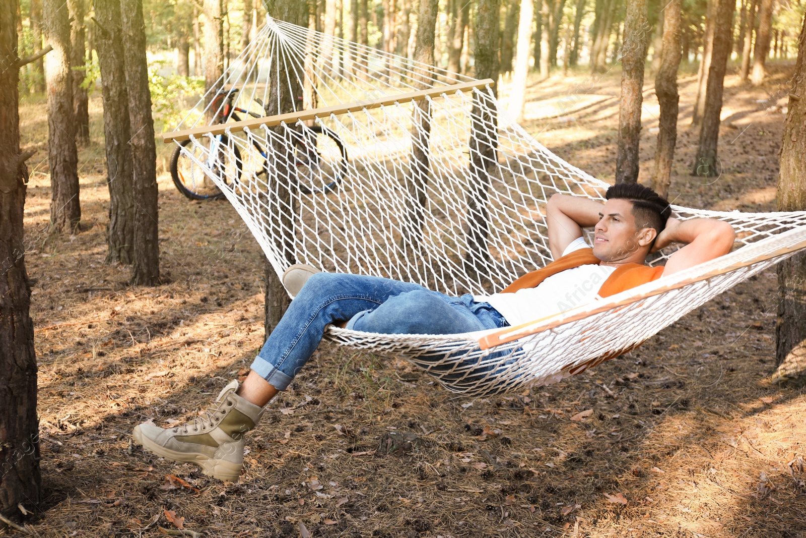 Photo of Handsome man resting in hammock outdoors on summer day