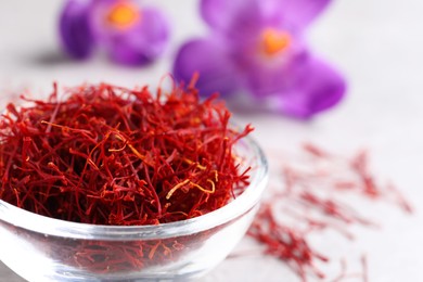 Photo of Dried saffron and crocus flowers on light table, closeup. Space for text