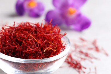 Dried saffron and crocus flowers on light table, closeup. Space for text