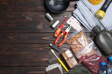 Earthquake supply kit on wooden table, flat lay. Space for text