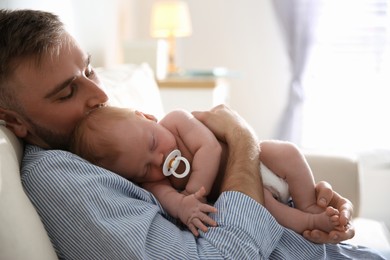 Photo of Father with his newborn son at home