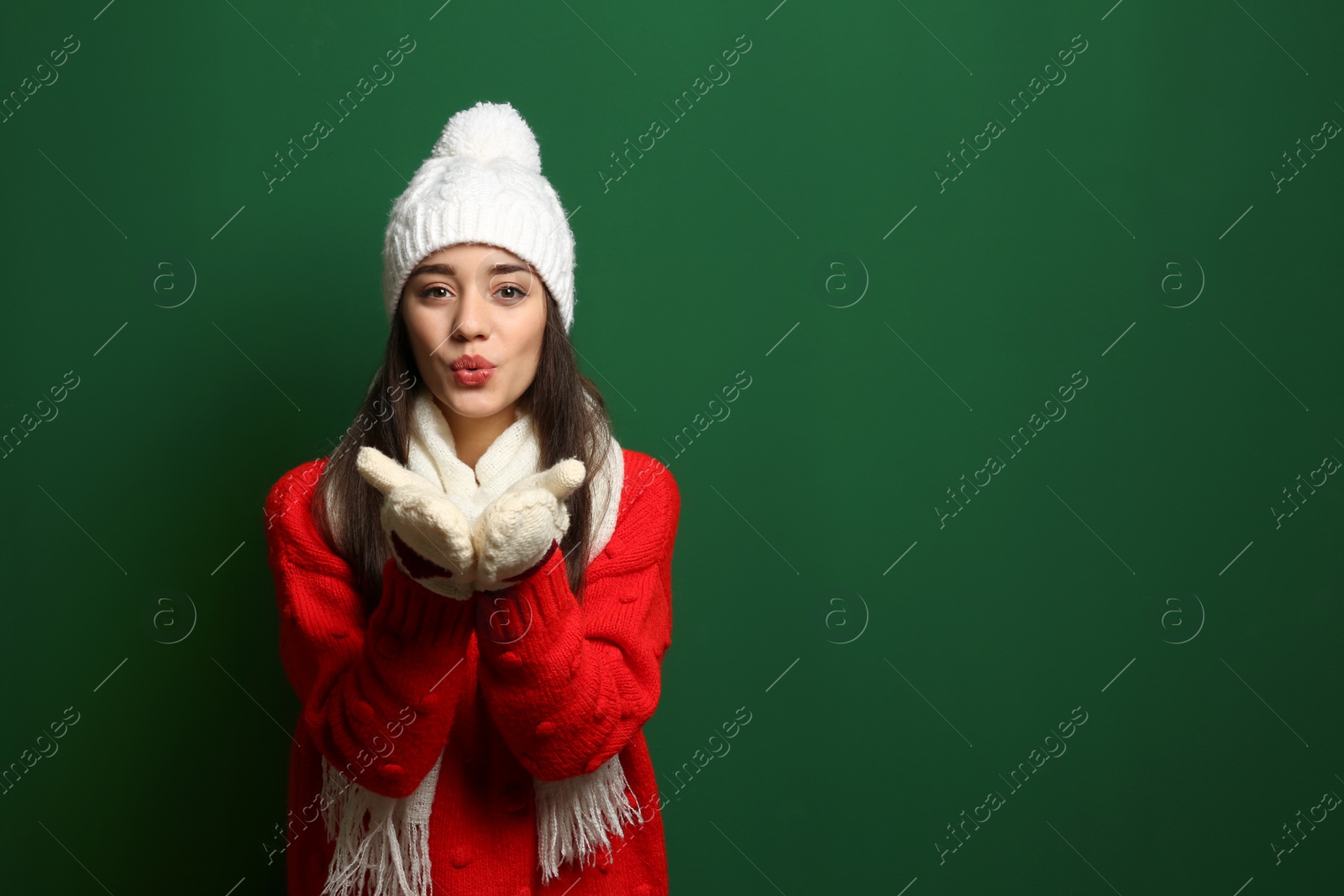 Photo of Young woman wearing warm clothes on color background, space for text. Winter season